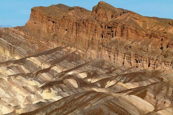 This is a sedimentary rock formation that's part of Zabriskie Point, located within Death Valley, California. It's composed of sediments from Furnace Creek Lake which dried up roughly 5 million years ago. Millions of years of erosion have left the sediment layers exposed.